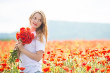 Young beautiful blonde woman in poppy field