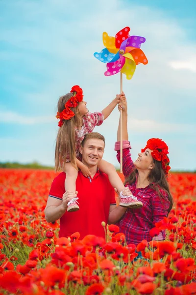 Schwangere Frau, ihr Mann und ihre Tochter im Mohnfeld — Stockfoto