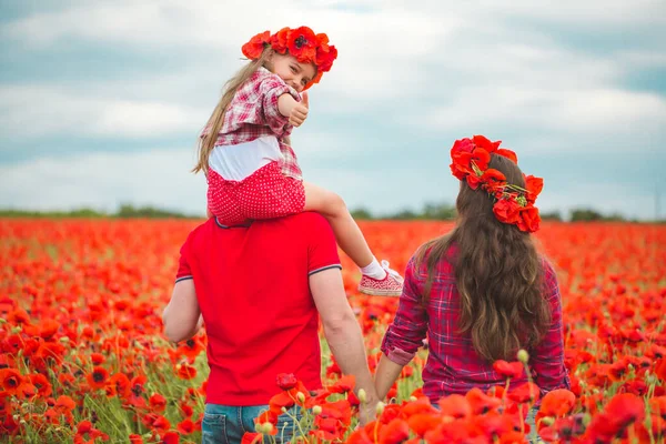 Zwangere vrouw haar man en hun dochter in papaverveld — Stockfoto