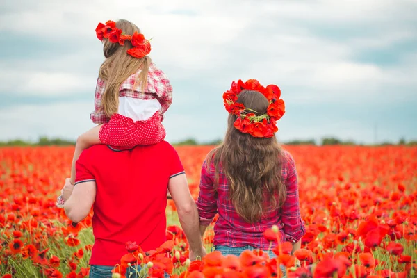 Pregnant woman her husband and their daughter in poppy field — 스톡 사진