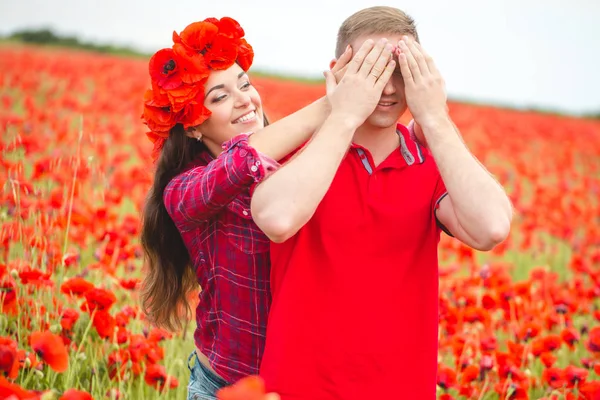 Young couple of lovers in a poppy field — 스톡 사진