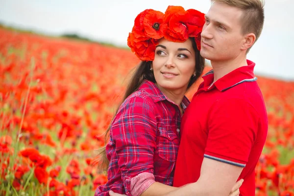 Jeune couple d'amoureux dans un champ de pavot — Photo