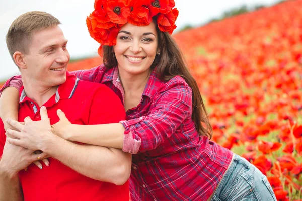 Young couple of lovers in a poppy field — Stock Photo, Image