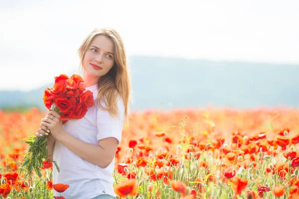 Joven hermosa mujer rubia en el campo de amapola — Foto de Stock