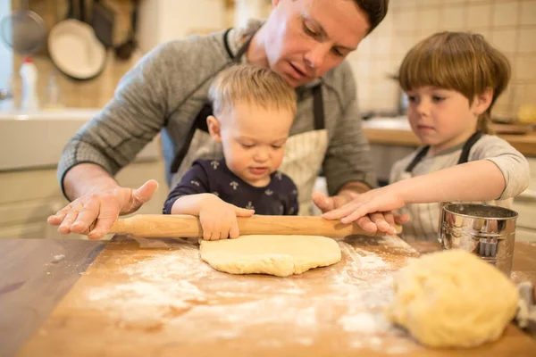 Pai e filhos fazem biscoitos — Fotografia de Stock
