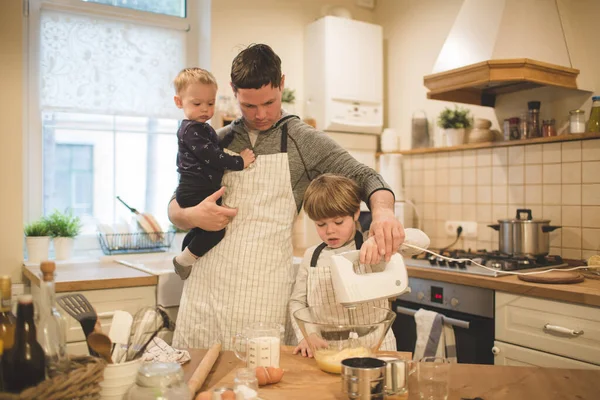 Dad and sons make cookies