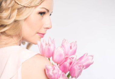 Luxurious blonde with a bouquet of tulips