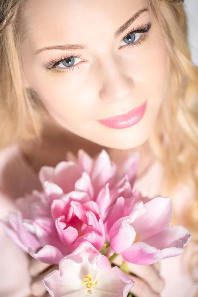 Luxurious blonde with a bouquet of tulips — Stockfoto