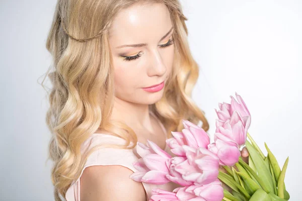 Luxurious blonde with a bouquet of tulips — 图库照片