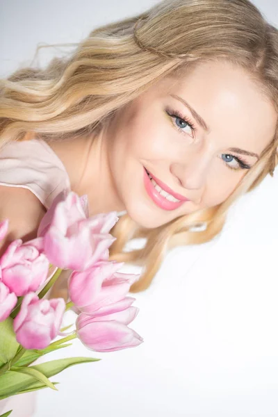 Luxuriöse Blondine mit einem Strauß Tulpen — Stockfoto