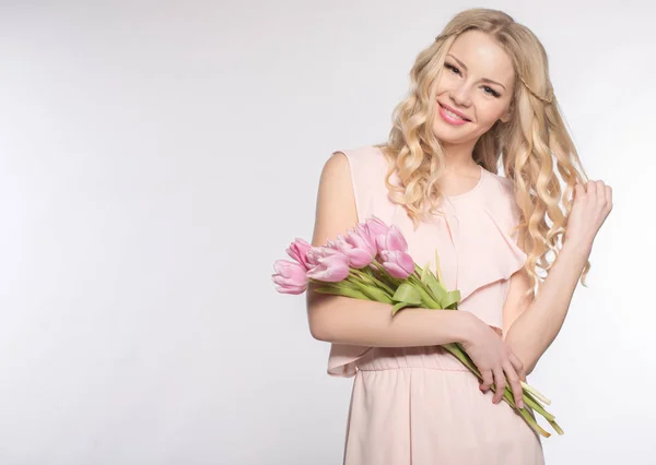 Luxurious blonde with a bouquet of tulips — Stock Photo, Image