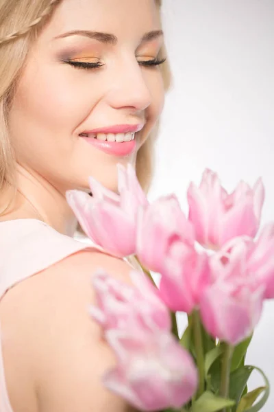 Luxurious blonde with a bouquet of tulips — Stockfoto