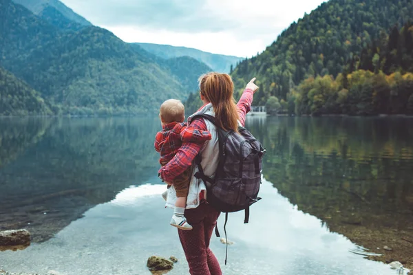 Mamá y su hijo caminan por el lago — Foto de Stock