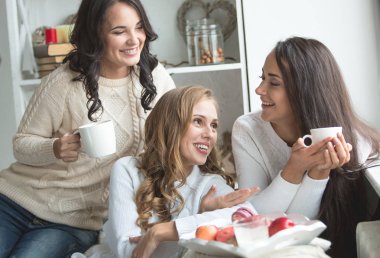 Sıcak bir oturma odasında üç arkadaş.