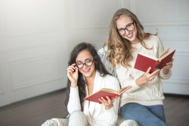 Gözlüklü kızlar kitap okur.