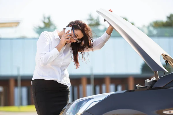 Une femme près d'une voiture cassée — Photo