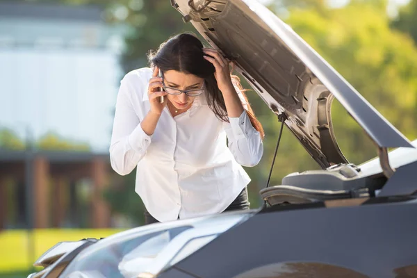 Eine Frau in der Nähe eines kaputten Autos — Stockfoto