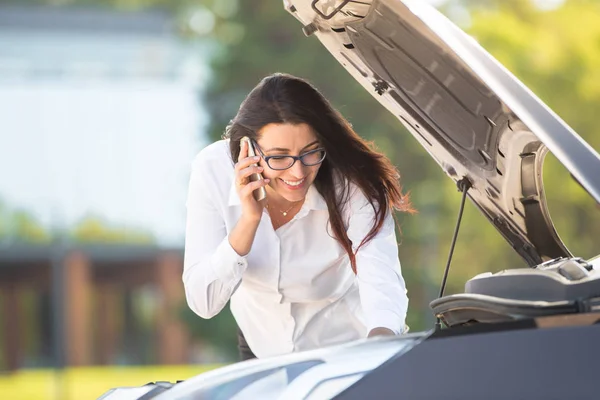 Eine Frau in der Nähe eines kaputten Autos — Stockfoto