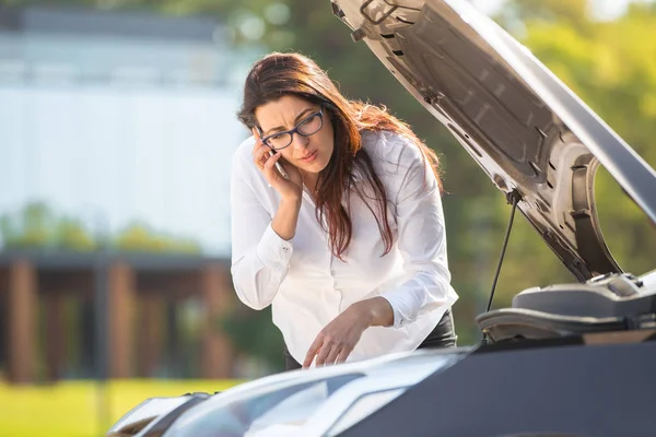 Une femme près d'une voiture cassée — Photo