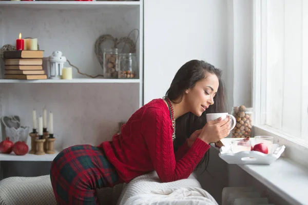 Mädchen auf der Couch mit einer Tasse Heißgetränk — Stockfoto