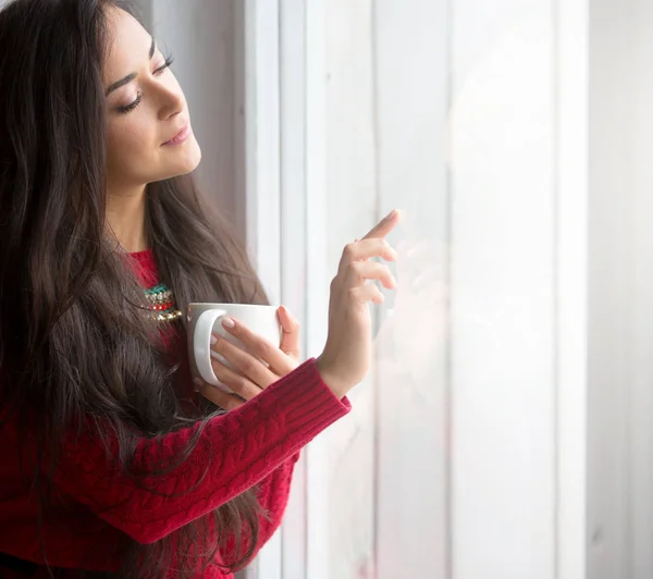 Meisje op de bank met een kopje warme drank — Stockfoto