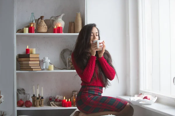 Menina no sofá com uma xícara de bebida quente — Fotografia de Stock