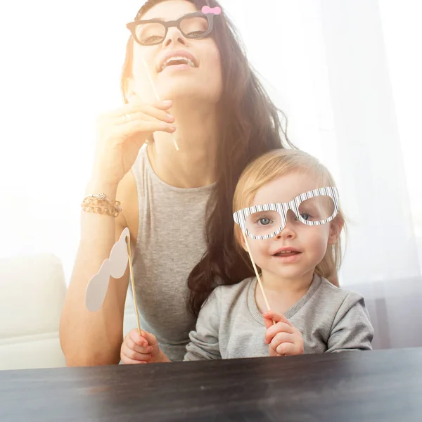 Moeder en haar dochter met een papier-accessoires. — Stockfoto