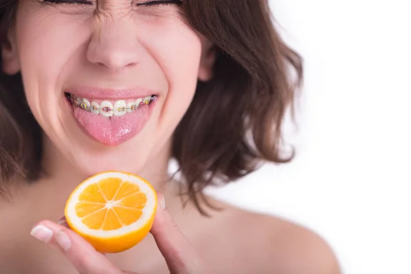 若い女性の顔をレモンフルーツで閉じます 歯列矯正具 — ストック写真