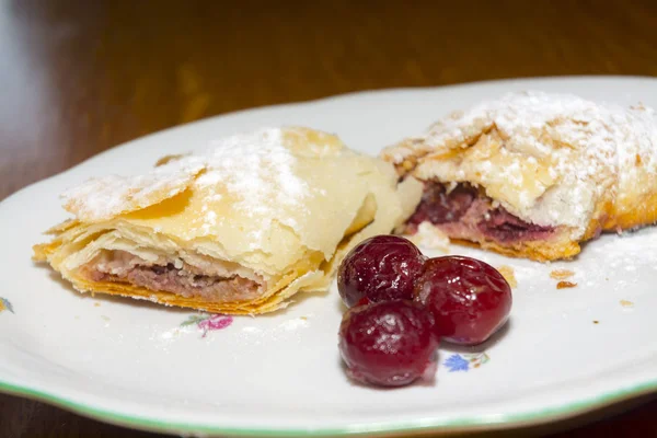 Teller Sauerkirschstrudel auf einem Holztisch — Stockfoto