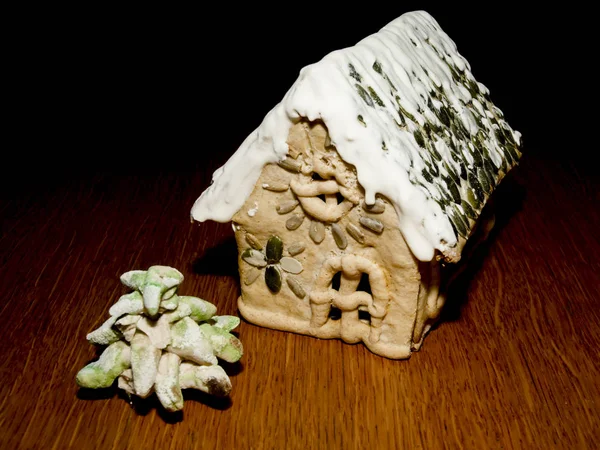 Casa de gengibre e um pinheiro na mesa de madeira — Fotografia de Stock