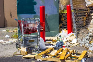 Alışveriş sepetlerini yanındaki çöp yığını