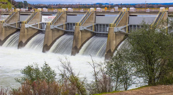 Wehren lassen Wasser in lokalem Fluss frei, um Überflutungen zu verhindern — Stockfoto