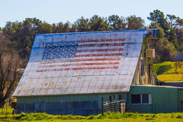 American Flag Painted On Old Tin Roof Of Barn