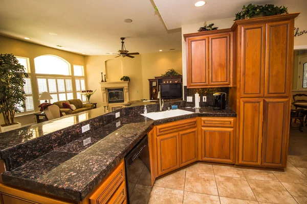 Cocina moderna con encimera de granito negro y gabinetes de madera ricos — Foto de Stock