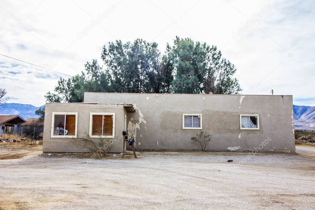 Vacant Adobe Home With Boarded Up Windows