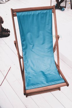 Beyaz ahşap zemin üzerinde mavi şezlong