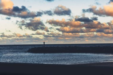 Gün batımında deniz feneri silueti