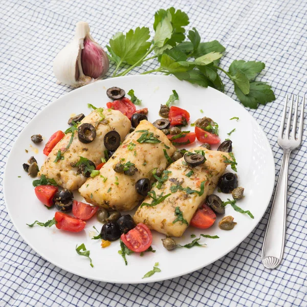 Cod fillets with black olives and tomato — Stock Photo, Image