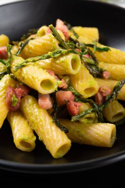 Bir tabak rigatoni makarna, domuz pastırması ve yabani kuşkonmaz, İtalyan mutfağı.