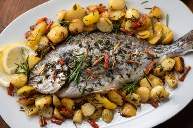 Yanında patates ve biberiye ile pişirilmiş deniz kepeği.