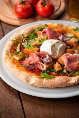 Prosciutto, mozzarella, roket ve domates soslu lezzetli gurme pizza. 