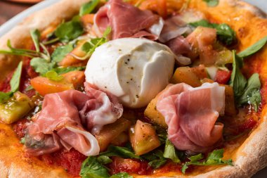 Prosciutto, mozzarella, roket ve domates soslu lezzetli gurme pizza. 