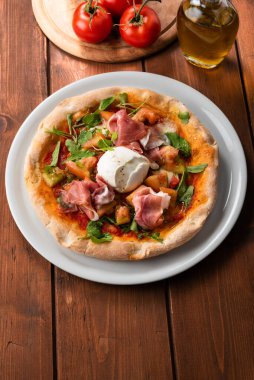 Prosciutto, mozzarella, roket ve domates soslu lezzetli gurme pizza. 