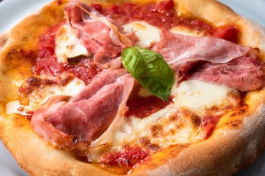 Jambonlu lezzetli pizza, mozzarella ve domates soslu. 