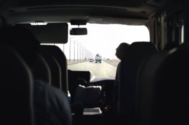 Otoyoldaki otobüs. Koç, mekik ya da minivan. Taksi minibüsüyle havaalanı transferi. Arka koltuktan yolcu iç görüntüsü. Turist turu gezisi. Toplu taşıma. Arabanın içinde. Otoyol trafiği.
