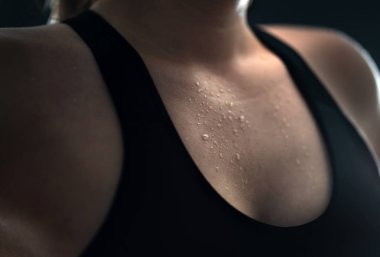 Ter içinde kalmış. Spor yaptıktan sonra terli kadın, ağır kardiyo ya da yağ yakma eğitimi. Yoga eğitmeni, yorgun sporcu ya da kişisel antrenör. Islak kadın göğsünü su damlalarıyla kapatın..