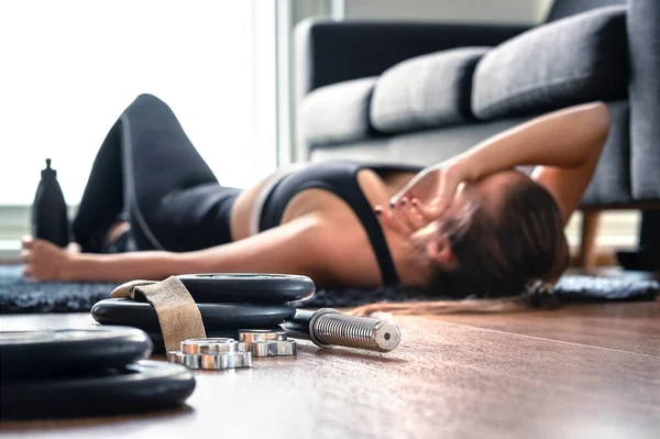 運動やトレーニングの後に疲れている オーバートレーニングの概念 ホームジムでの激しいカーディオトレーニングの後 床呼吸と休息に横たわって疲れ女性 悲しいフィットネス選手 あまりうまくいかない — ストック写真