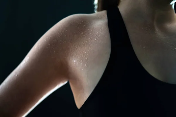Sweaty woman after gym workout, heavy cardio or fat burning training. Sweat on wet skin. Tired fitness athlete, yoga instructor or personal trainer. Exhausted after exercise. Arm and armpit. Low key.