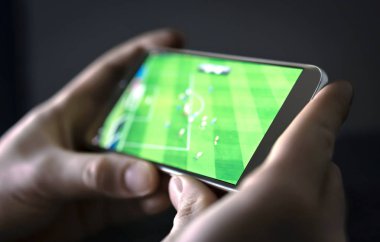 Watching football and sport stream with mobile phone. Man streaming soccer game live, video replay or highlights online with smart device. Sports fan and program of tv network in smartphone screen. clipart