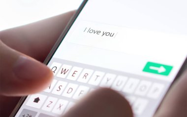 Seni seviyorum mesajını cep telefonuyla gönderiyorum. Çevrimiçi randevu, mesajlaşma ya da kandırmaca konsepti. Romantizm sahtekarlığı, dolandırıcılık ya da akıllı telefonla kandırma. Yorum yazan adam. Sahte profil. İnternet güvenliği.